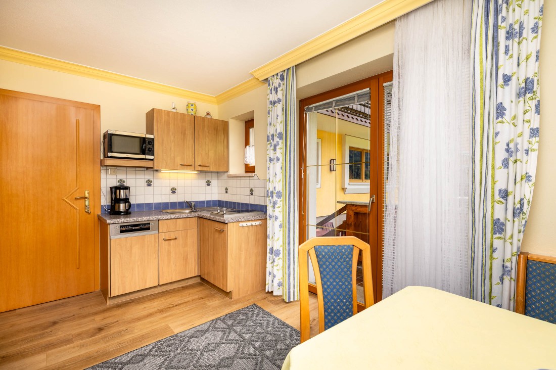 Wohnküche mit Esstisch und Zugang zum Garten