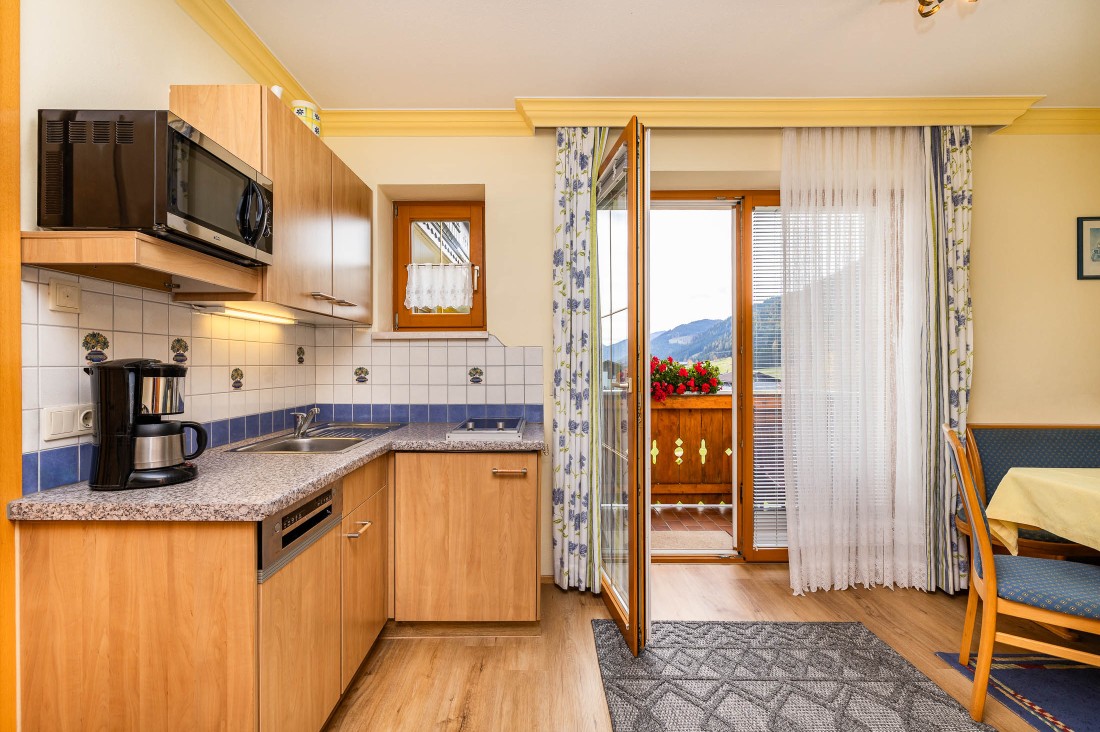 Wohnküche mit Esstisch und Zugang zum Garten