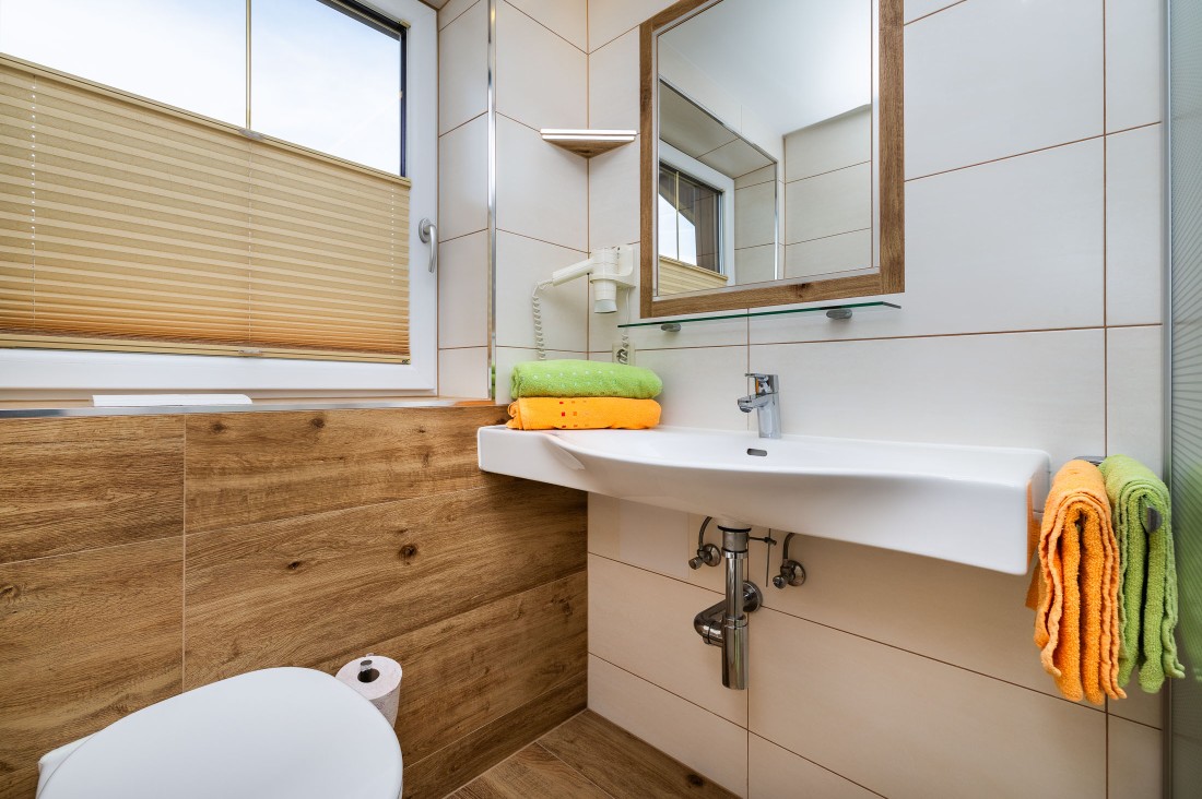 Badezimmer mit Waschbecken, Dusche und WC